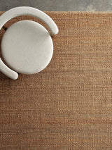 Armadillo Nest Rug in Natural, a second view of the handwoven jute flatweave rug in a styled interior