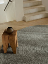Armadillo Nimbus Rug in Oakmoss, a second view of the hand-braided new zealand wool rug in a styled interior