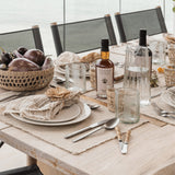 Pom Pom At Home Oakville natural linen-cotton placemats with frayed edges set on a rustic dining table