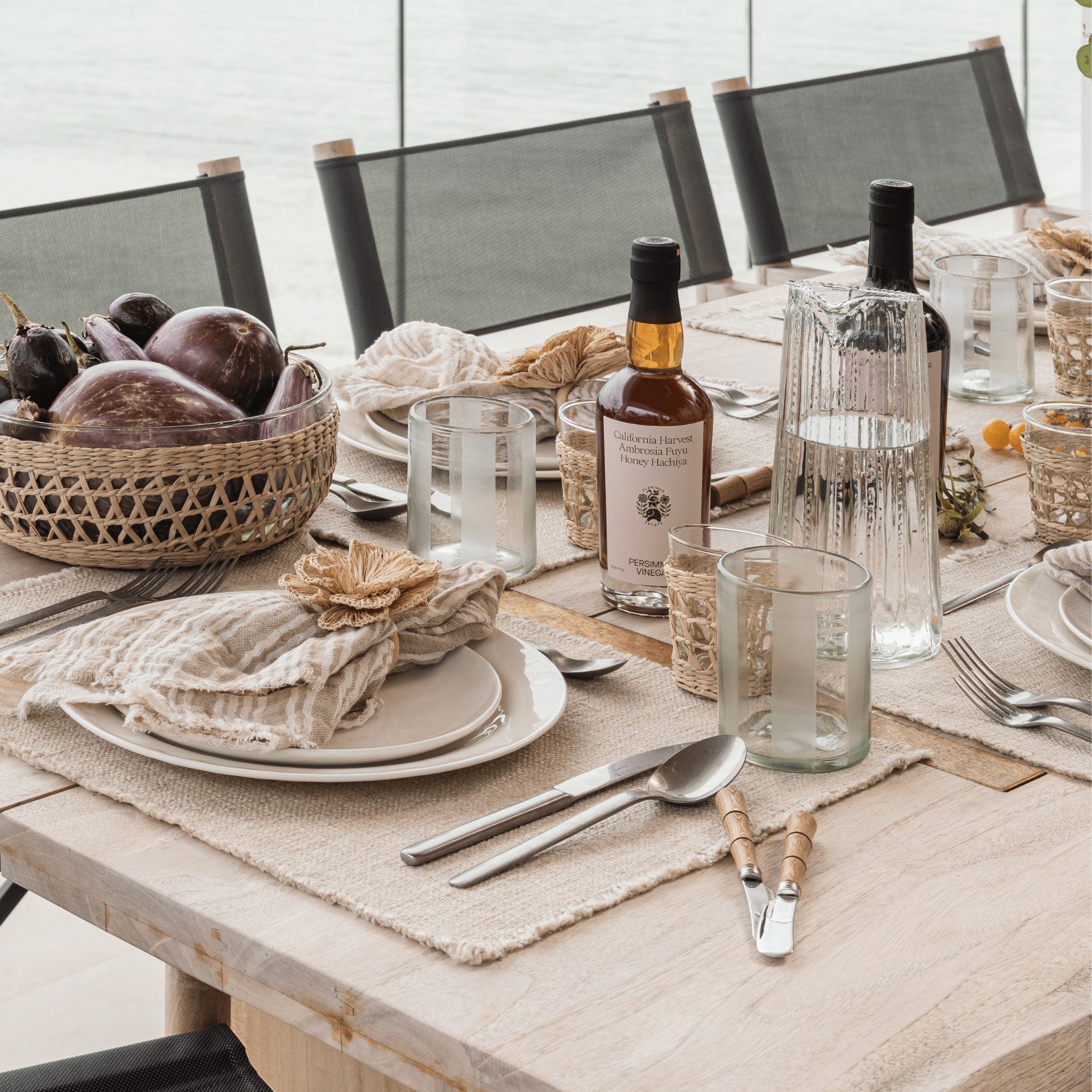Pom Pom At Home Oakville natural linen-cotton placemats with frayed edges set on a rustic dining table