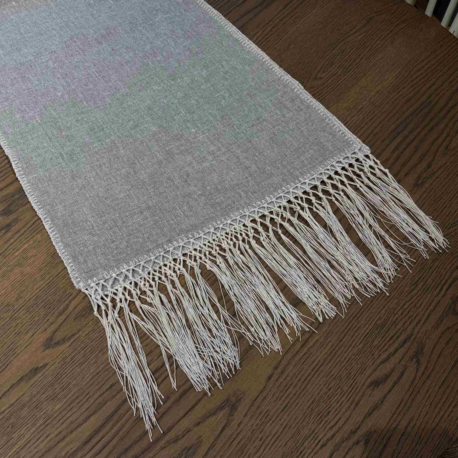 Elise Gray & Cream Table Runner styled on a dining table — detail view showing embroidered pattern and tassel ends, by One Bi One