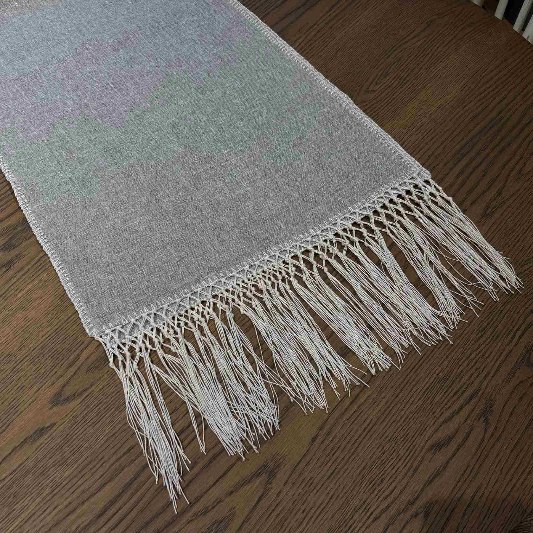 Elise Gray & Cream Table Runner styled on a dining table — detail view showing embroidered pattern and tassel ends, by One Bi One