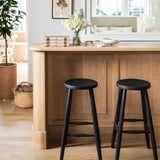 Calimia Home Omah Stool set in black stained wood with round seats and tapered legs at a kitchen breakfast bar
