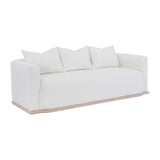 Calimia Home Owens sofa in white Belgian linen with a curved back and natural oak plinth base on a white background.
