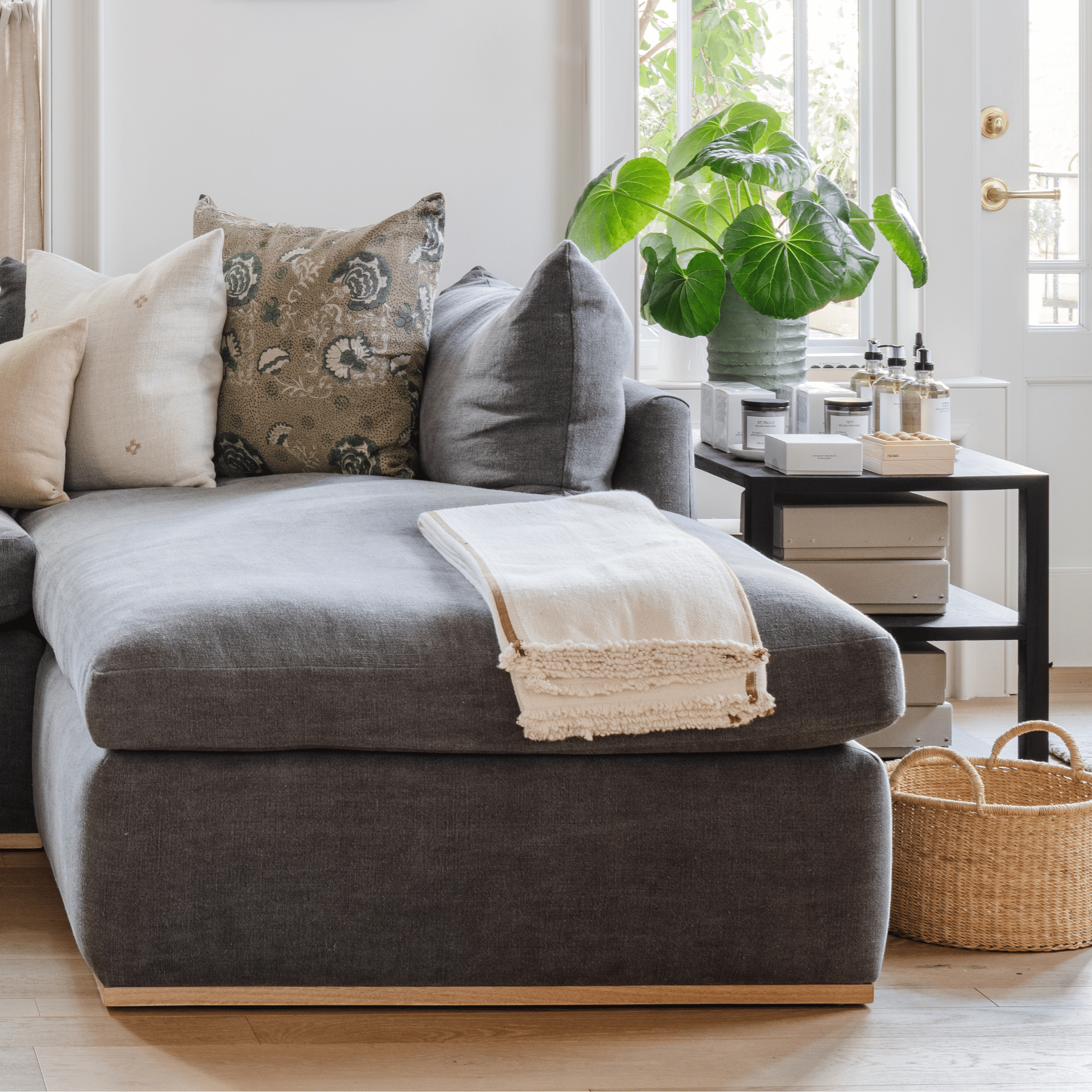 Calimia Home Palermo side table in black oak finish styled next to a grey sofa with a plant and home accessories