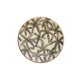 Round ceramic plate with green leaf pattern on a white background