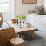 Palma Rectangular Coffee Table in natural oak by Grove & Anchor, low plinth-style profile, styled with a tray and vase on a gray rug beside woven seating