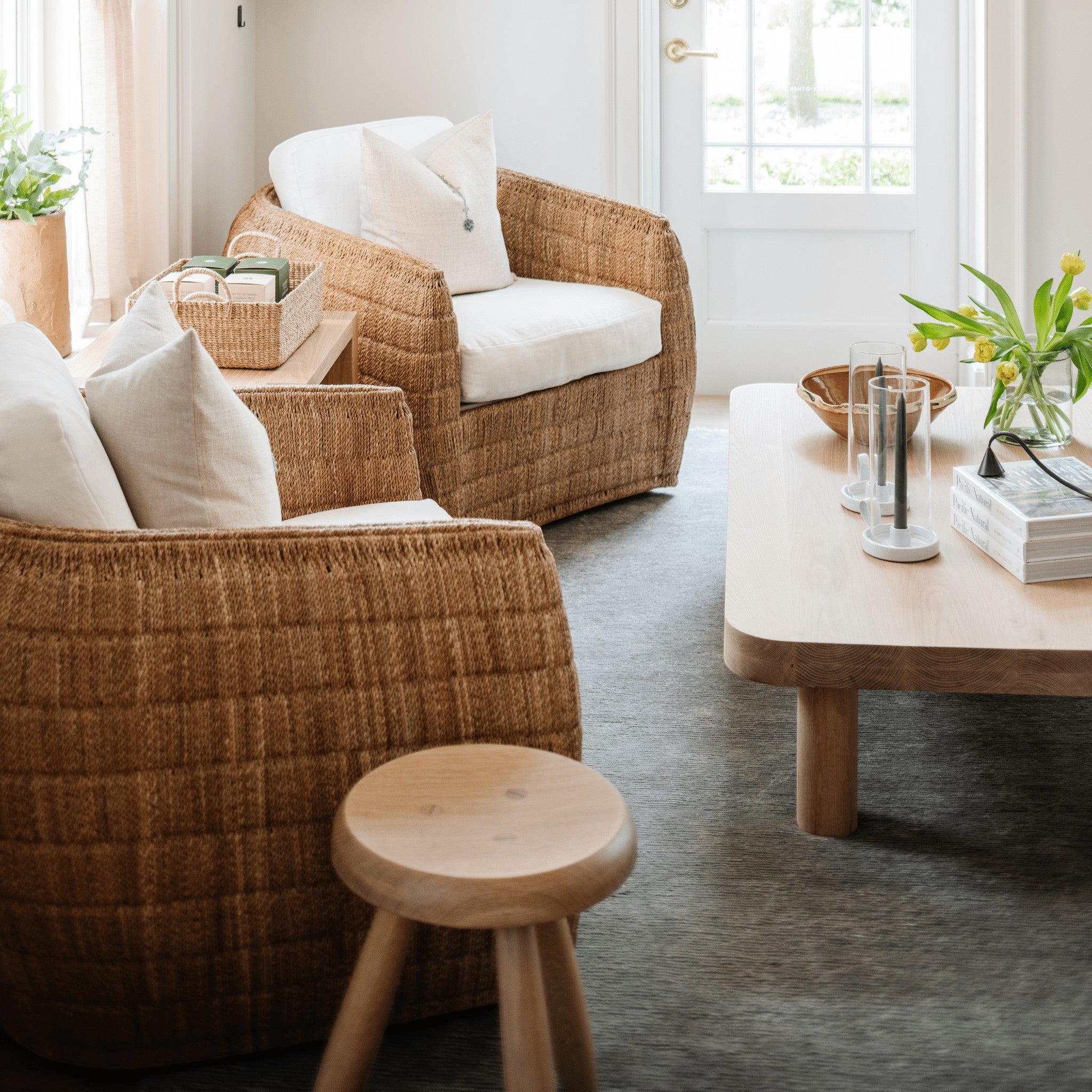 Palma Rectangular Coffee Table in natural oak by Grove & Anchor, styled in a living room with rattan armchairs and a wood stool