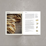 Calimia Home Pasta cookbook open to a page featuring hand-cut fettuccine instructions and illustrations.