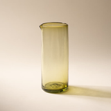 Water being poured from the peridot glass pitcher into a matching tumbler