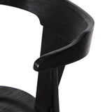 Calimia Home Ripley dining chair in matte black solid wood with a sculptural ergonomic backrest and wood grain texture.