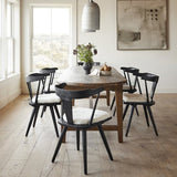 Calimia Home Ripley dining chairs in matte black solid wood with white seat cushions arranged around a rustic table.