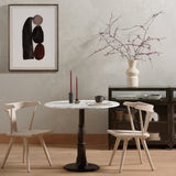 Two light wood Calimia Home Ripley dining chairs arranged around a round marble bistro table in a modern room.