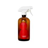 An amber glass Flamingo Estate Roma Heirloom Tomato Surface Cleaner bottle with bold red figure-8 label and white trigger spray on a white background.