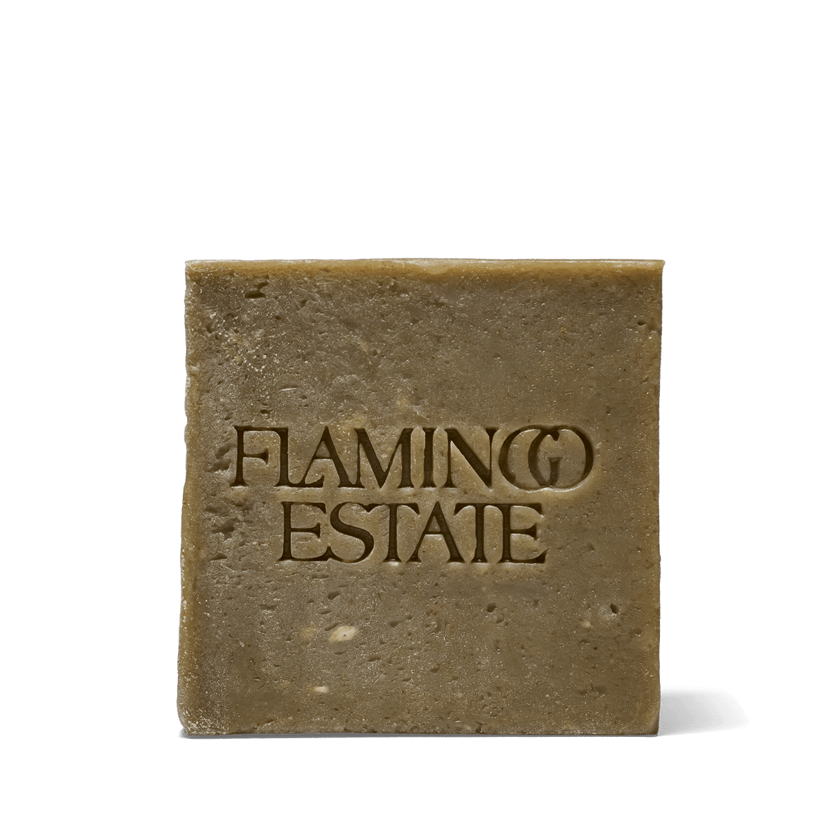 The olive-green Flamingo Estate Rosemary & Parsley Soap Brick, flecked with herbs and embossed with the brand wordmark, on a white background.