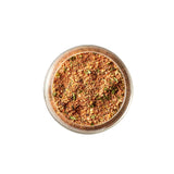 Calicutts Rotisserie Spice Blend with parsley, basil, thyme, lemon, garlic, and onion in a glass jar top view
