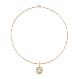 Close-up detail of bezel-set charm on gold rolo chain