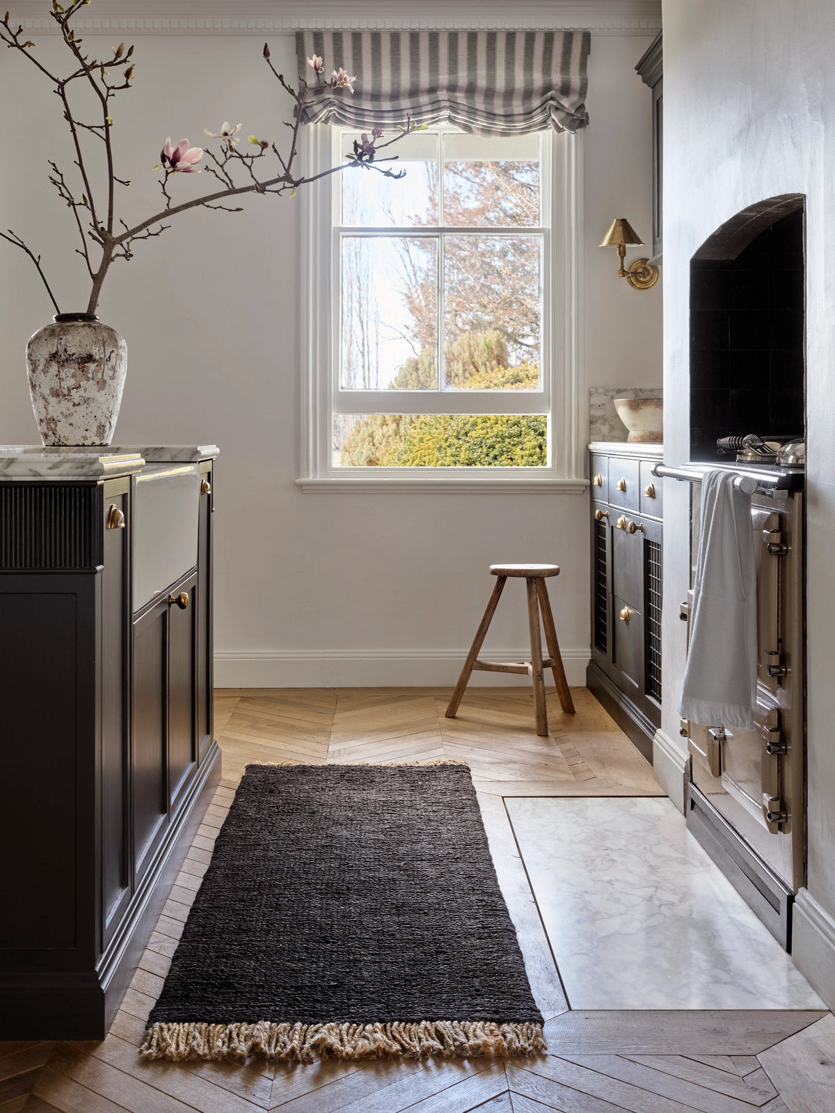 Armadillo Sahara Nook Rug in Charcoal, double-woven jute rug shown in a room setting