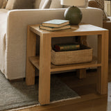 San Vincente Side Table in natural oak by Grove & Anchor, open lower shelf with a basket, styled beside an upholstered sofa, exclusive to Calimia Home