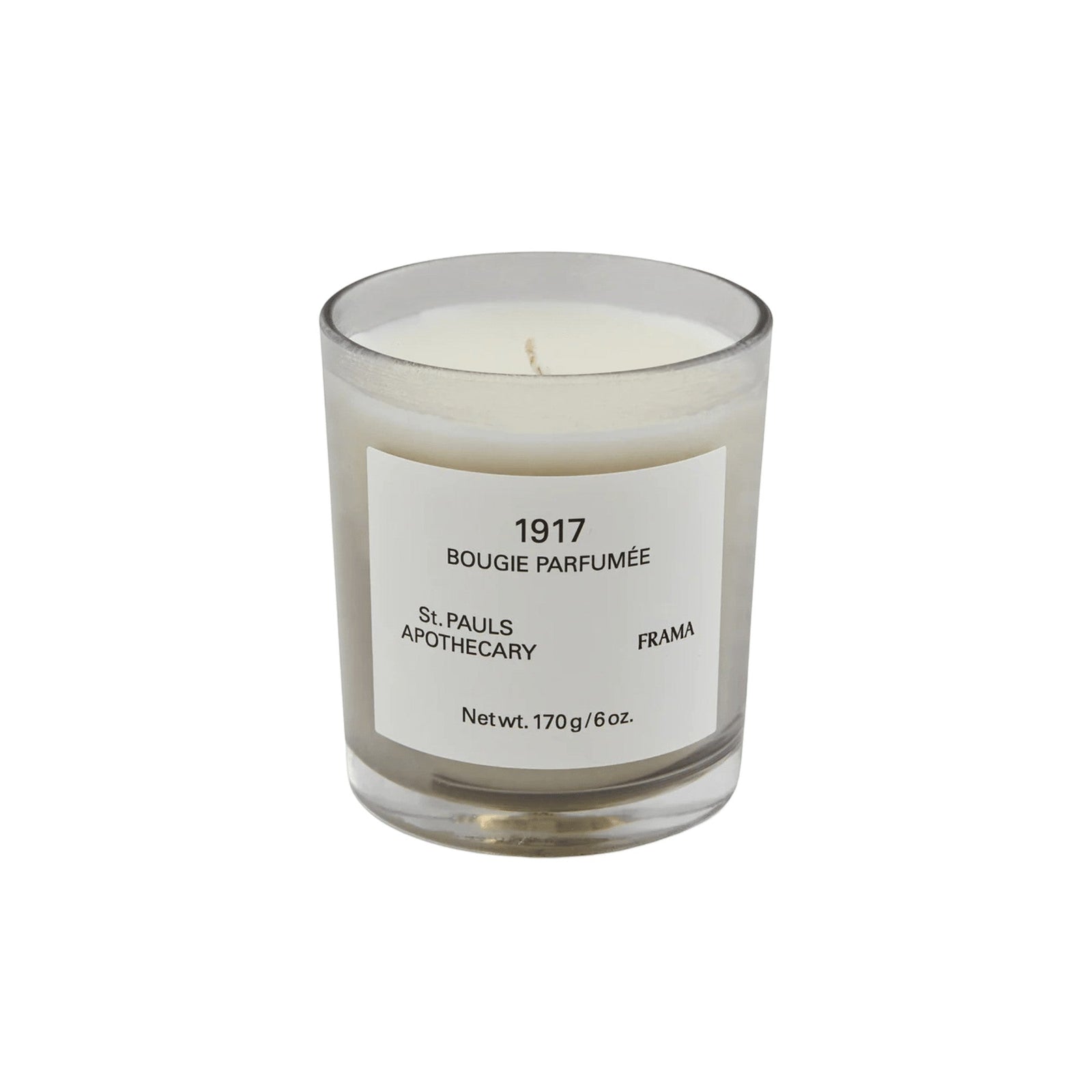 Frama 1917 scented candle in a clear glass jar with a minimalist white label and white wax.