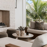 Be Home Seagrass Cage Pitcher with glass body and woven seagrass wrap on a patio coffee table.