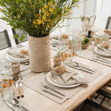 Be Home Seagrass Cage Tumbler with clear glass and handwoven natural seagrass wrap on a rustic dining table