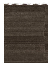 Armadillo Selva Rug in Walnut, corner close-up of the afghan wool pile and edge