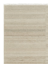 Armadillo Selva Rug in Oat, corner close-up of the afghan wool pile and edge