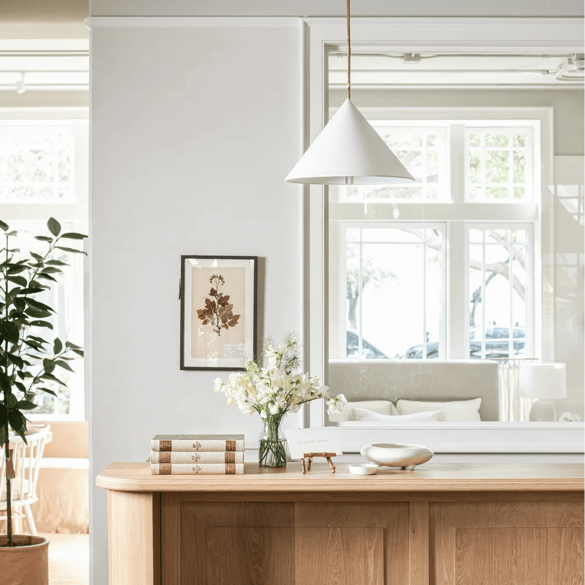 Slide Drop Pendant above the white oak counter with black stools at Calimia Home