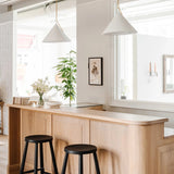 Two Slide Drop Pendants over the white oak counter with black wooden stools at Calimia Home