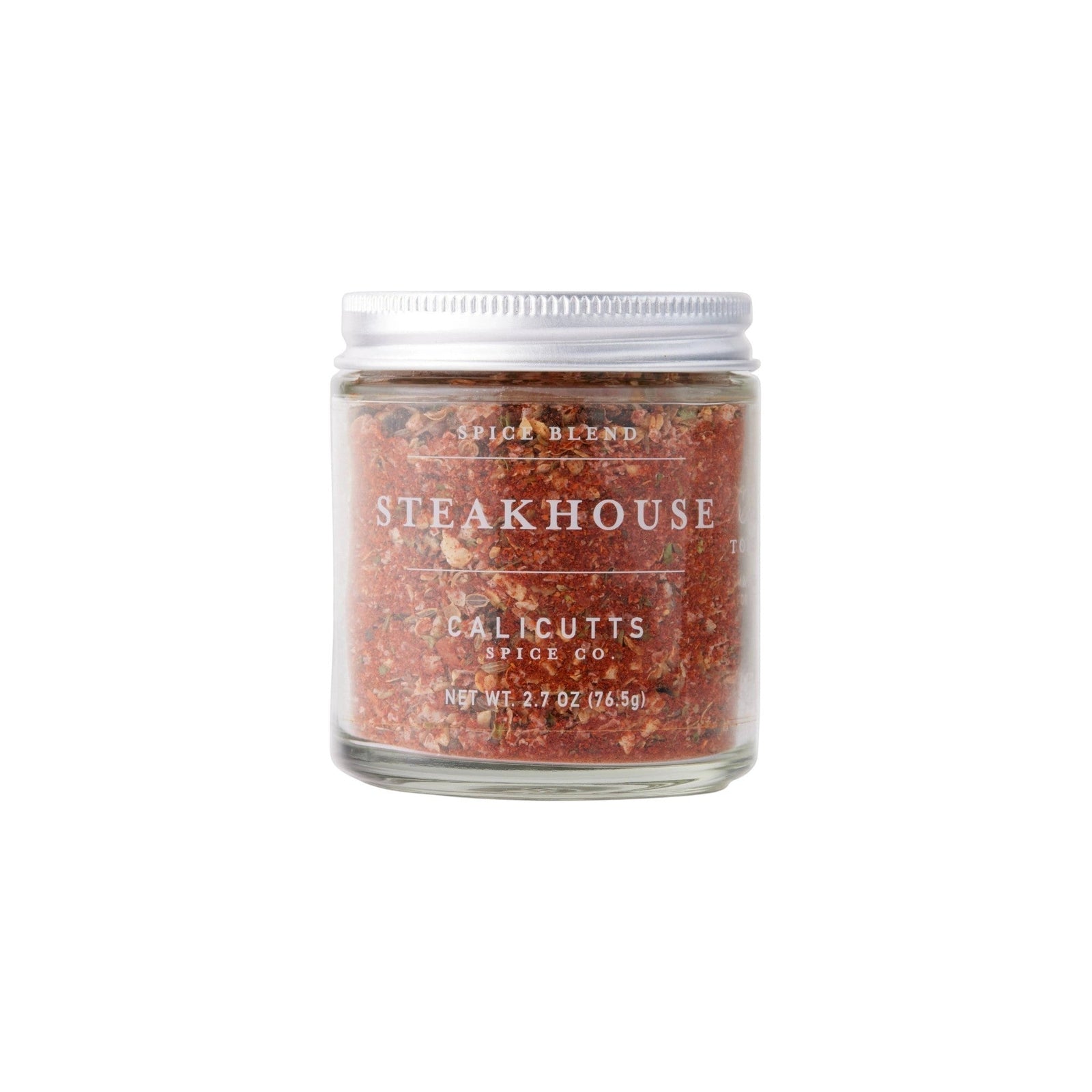 Calicutts Steakhouse spice blend in a clear glass jar with a silver lid, featuring red pepper and herbal flakes.