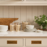 Calimia Home handcrafted stoneware medium plate in a neutral glaze, displayed on a kitchen counter with tableware.