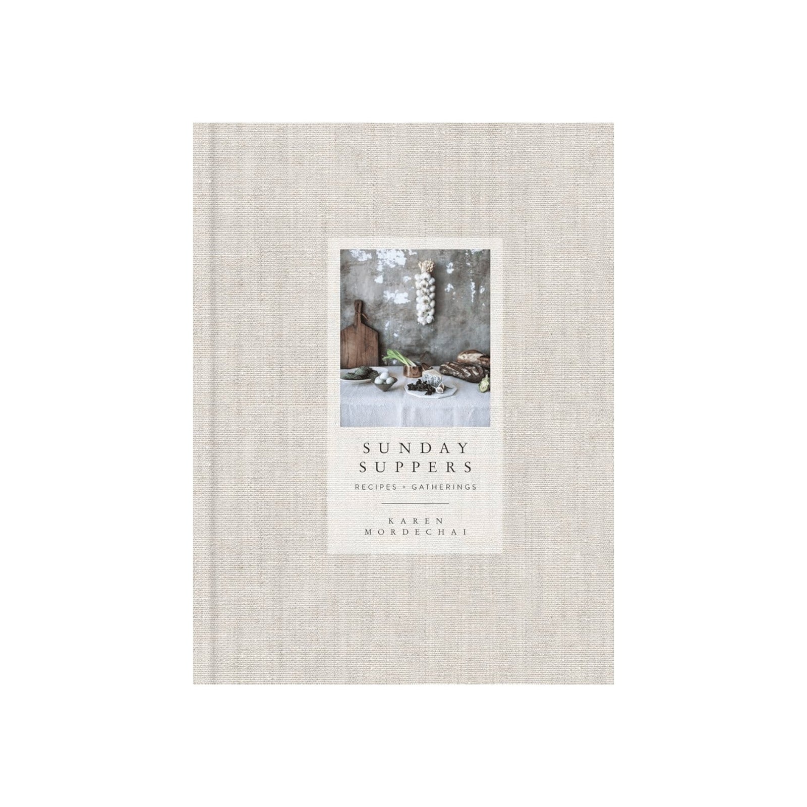 Calimia Home Sunday Suppers cookbook with a beige linen-bound cover and a rustic food photography inset.