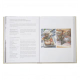 Calimia Home Sunday Suppers cookbook open to a burrata salad recipe page with rustic food photography