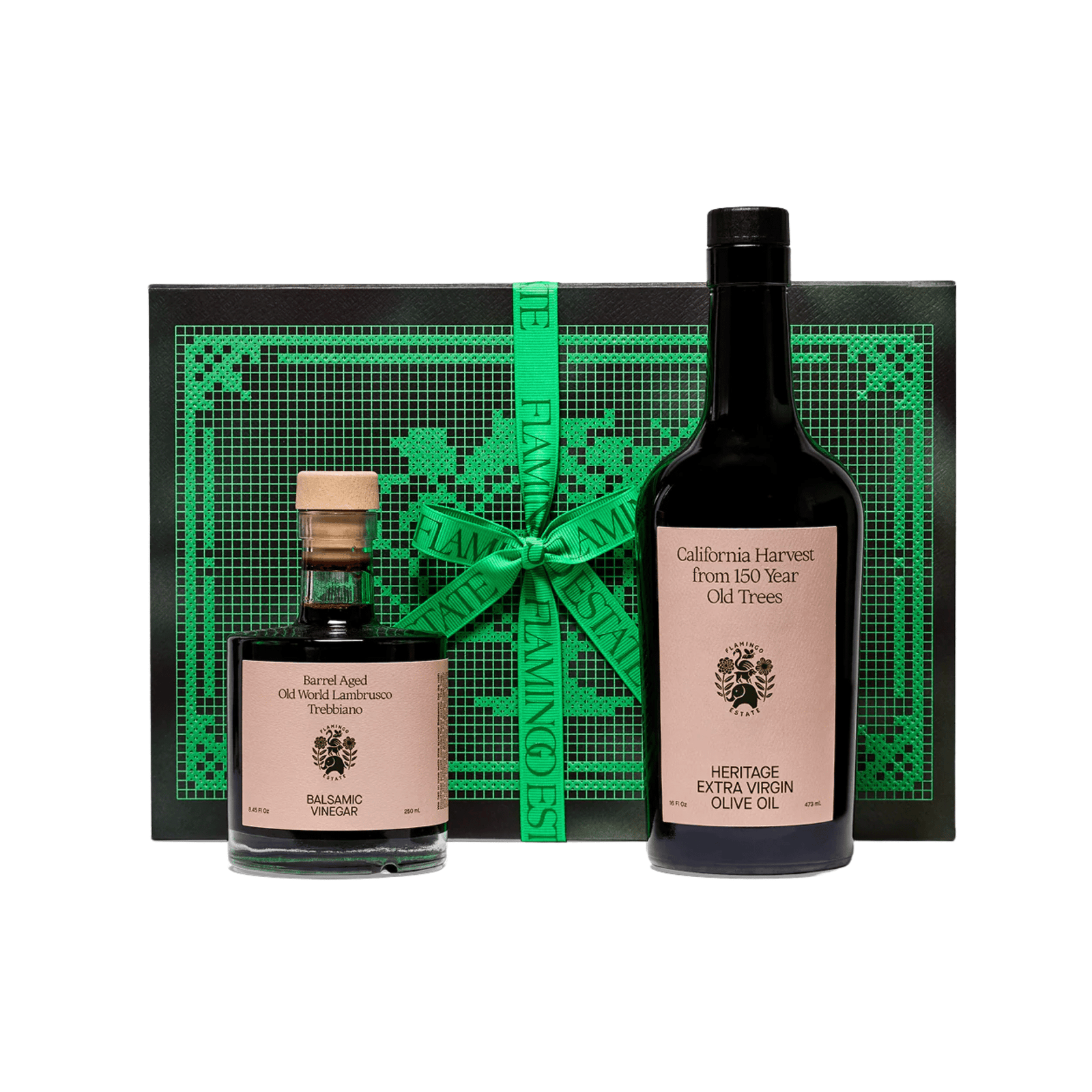 Flamingo Estate Tablemates Gift Set: a Heritage Extra Virgin Olive Oil bottle and Barrel Aged Balsamic Vinegar with cork stand before a black and green embroidered box tied with ribbon.
