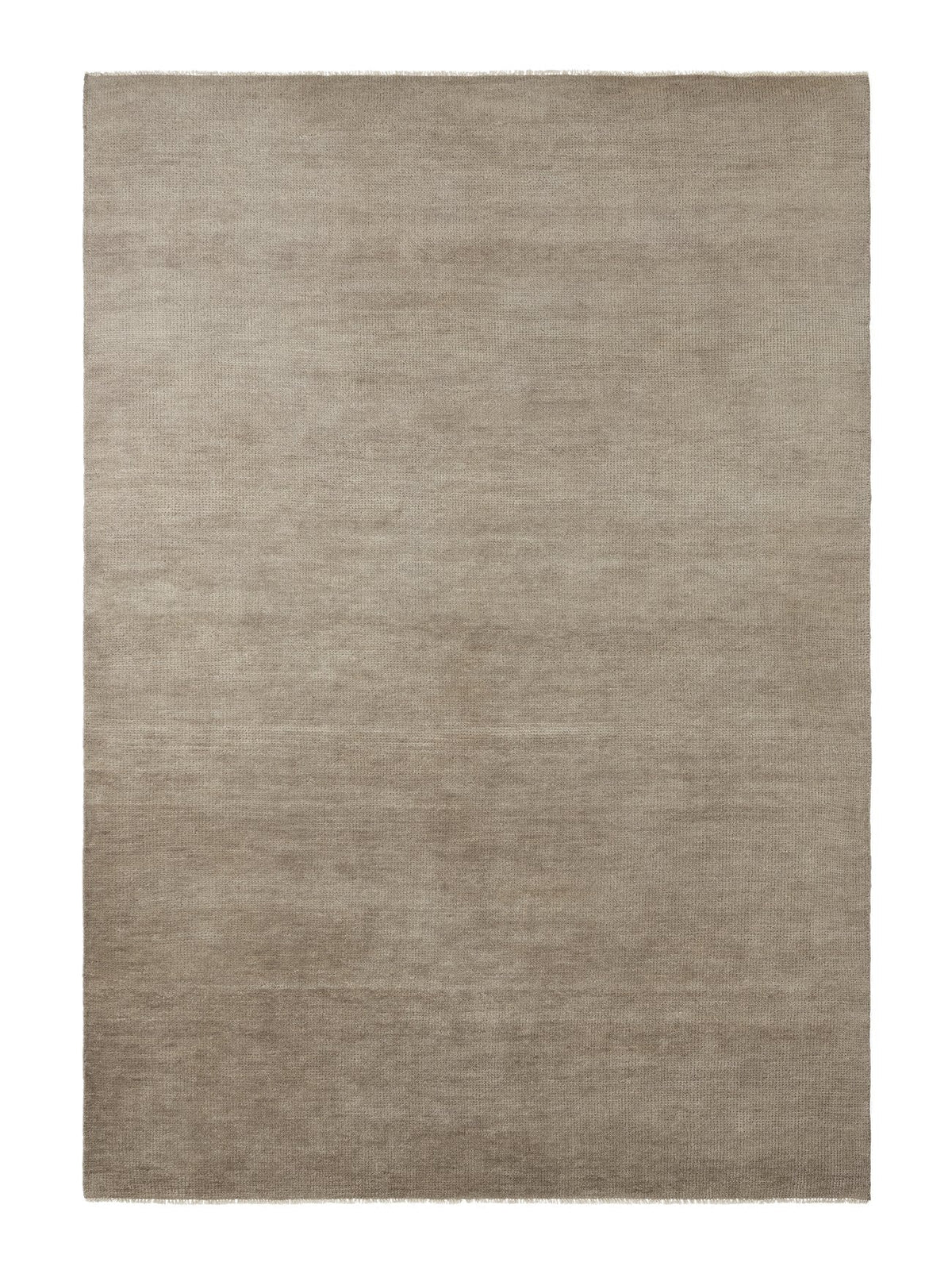 Armadillo Thatch Rug in Concrete, a second view of the hand-knotted wool rug in a styled interior