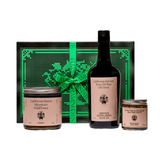 Flamingo Estate Chef's Kiss Gift Set: California Native Mountain Wildflower Honey, Heritage Extra Virgin Olive Oil, and Salsa Macha Chile Crisp lined up before the embroidered Flamingo Estate gift box.