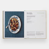 Calimia Home The Regional Italian Cookbook book open to a spread showing a salt cod recipe on a blue linen.