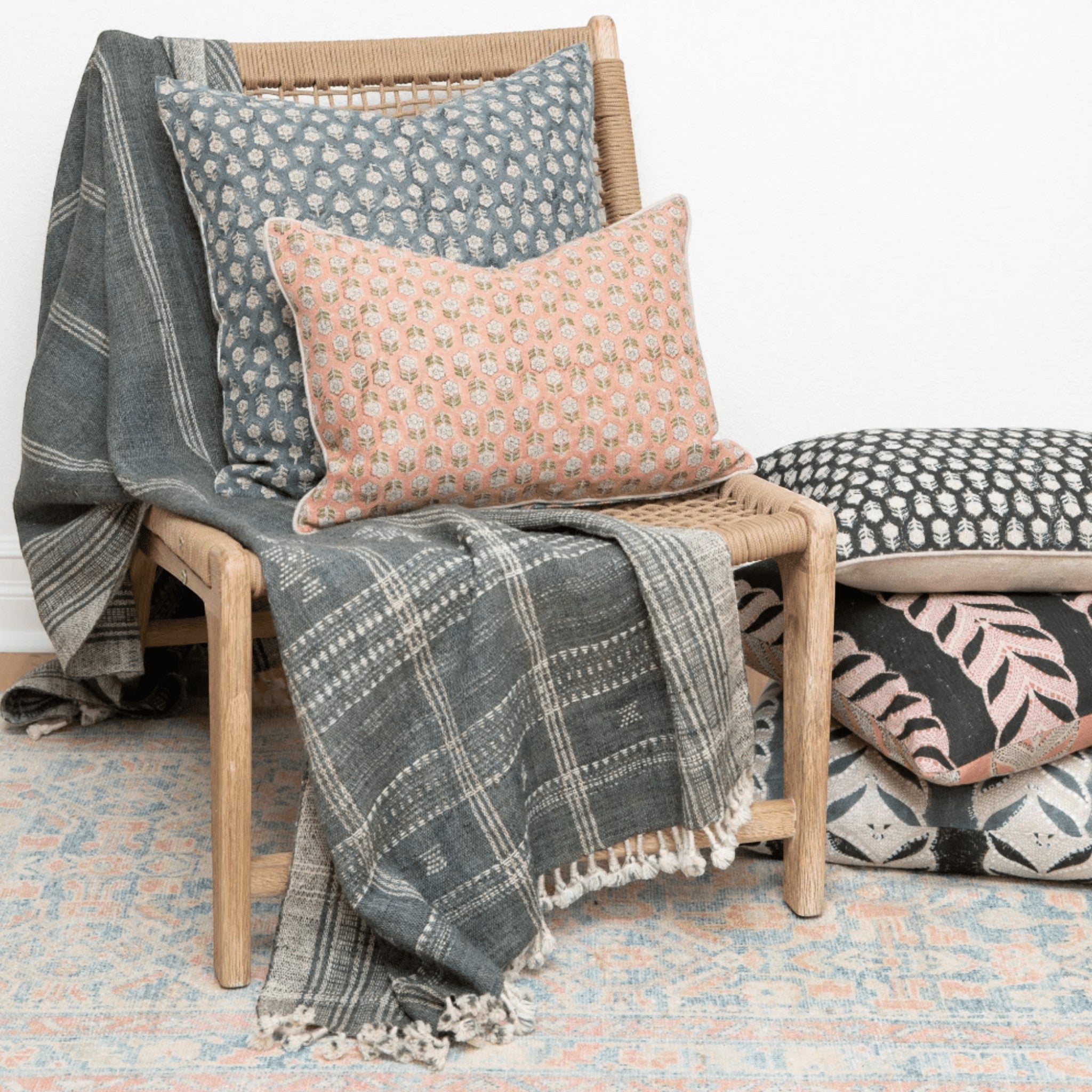 Calimia Home Tulsi teal floral hand-block-printed linen pillow with feather insert on a wooden chair with a throw