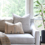 Calimia Home Tulsi white floral block-printed linen pillow with feather insert on a neutral armchair