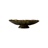 Vintage brass scallop shell dish in profile on its turned pedestal foot, showing iridescent green and rose patina across the lobes