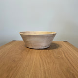 Collected by Schwung vintage woven rattan bread proofing basket on a wooden table for rustic kitchen decor