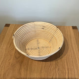 Collected by Schwung vintage woven bread proofing basket made of natural fiber on a wooden table