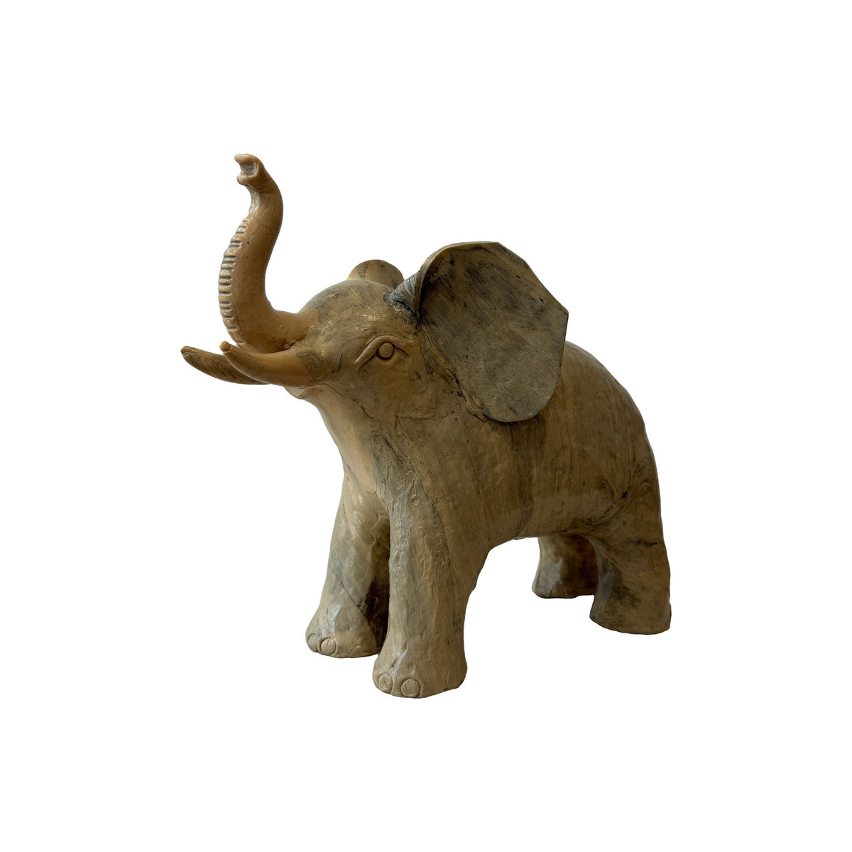 Carved wood elephant front three-quarter view showing separately cut ears, tusks and broad tool marks across the hide