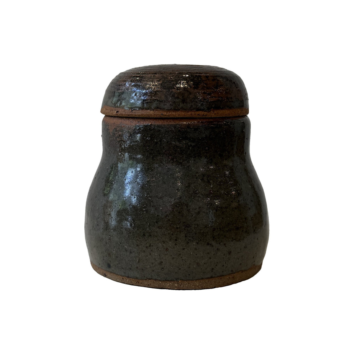 Studio pottery lidded jar in mottled near-black glaze with domed lid and bands of bare reddish clay at the foot and rim
