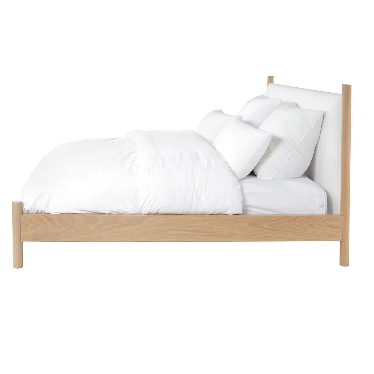 Calimia Home Wilfred Bed featuring a natural oak frame, low footboard, and white upholstered headboard side view.